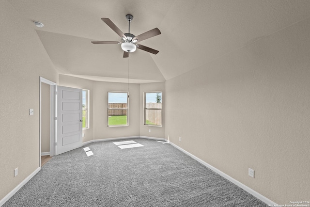 spare room with vaulted ceiling, ceiling fan, and carpet flooring