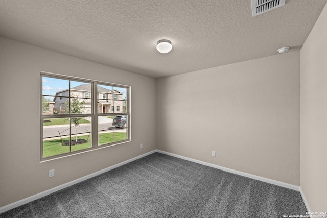 unfurnished room with carpet floors and a textured ceiling