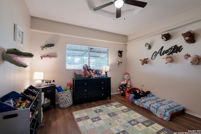 bedroom with ceiling fan, dark hardwood / wood-style floors, and a textured ceiling