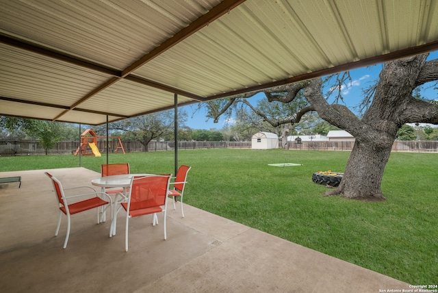 view of patio with a playground and a shed