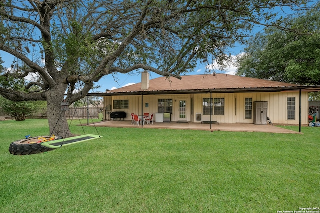 rear view of house featuring a lawn and a patio