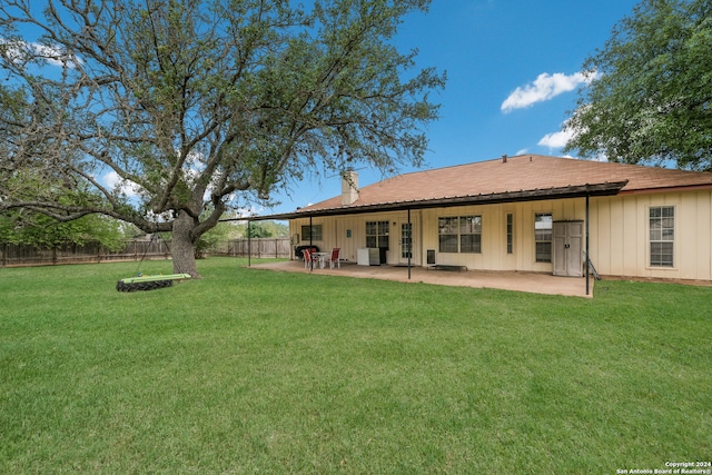 back of property with a yard and a patio