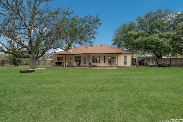 rear view of property with a lawn and a patio area