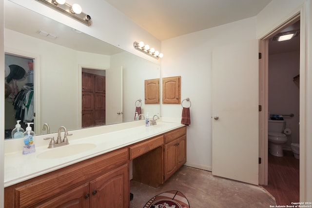 bathroom featuring vanity, concrete floors, and toilet