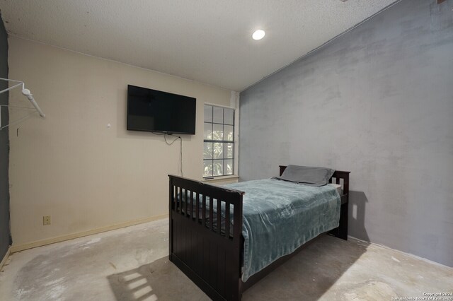 bedroom featuring concrete flooring and a textured ceiling