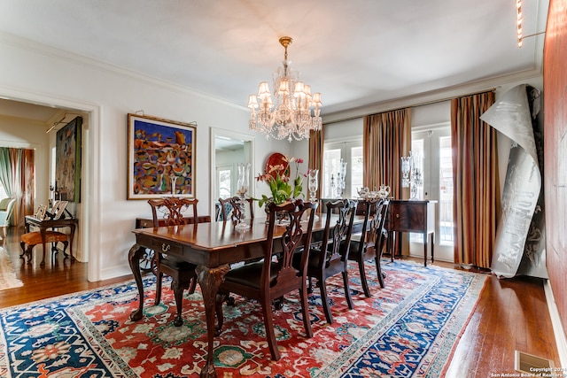 dining space with crown molding, dark wood-type flooring, and a notable chandelier