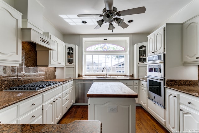 kitchen featuring sink, white cabinets, a kitchen island, appliances with stainless steel finishes, and ceiling fan