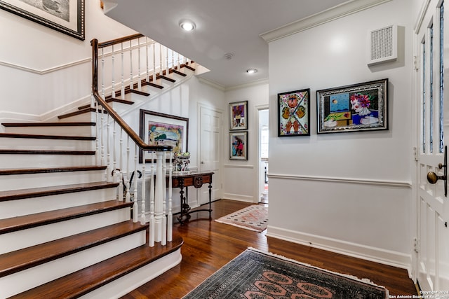 entryway featuring ornamental molding and dark hardwood / wood-style flooring