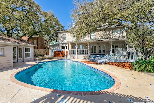 view of swimming pool featuring french doors and a patio