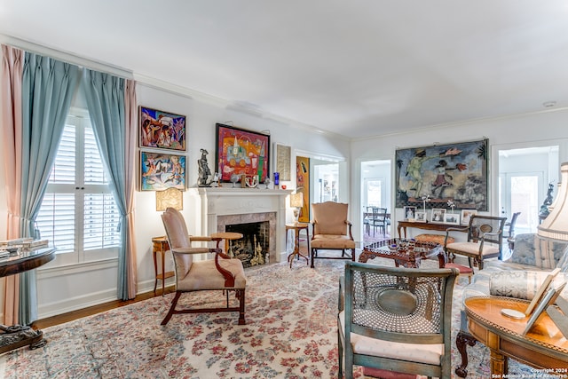 living room featuring a tiled fireplace, hardwood / wood-style flooring, and crown molding