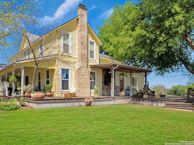 rear view of house featuring a yard