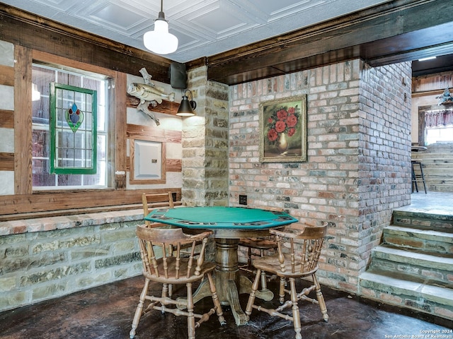 game room with brick wall and coffered ceiling