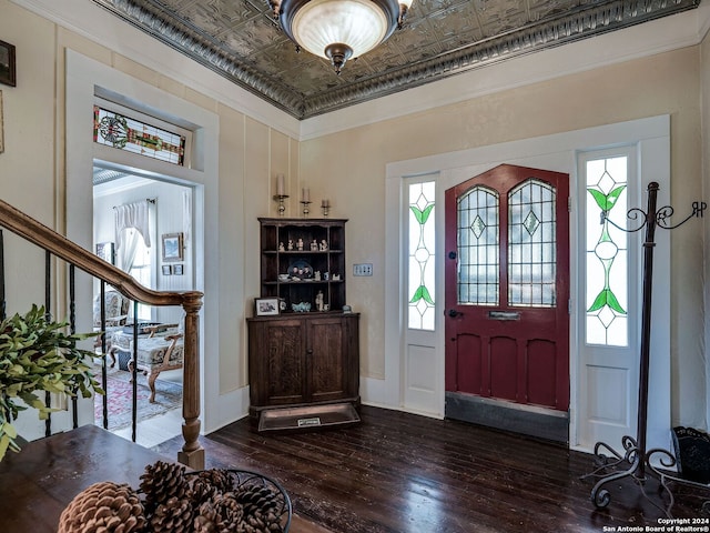 foyer entrance with dark hardwood / wood-style flooring and ornamental molding