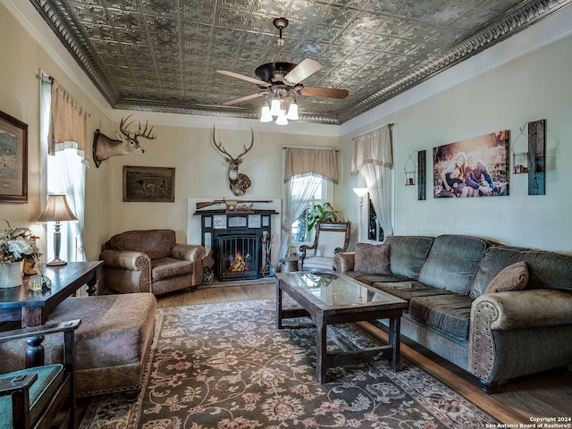 living room featuring dark wood-type flooring, ceiling fan, and crown molding