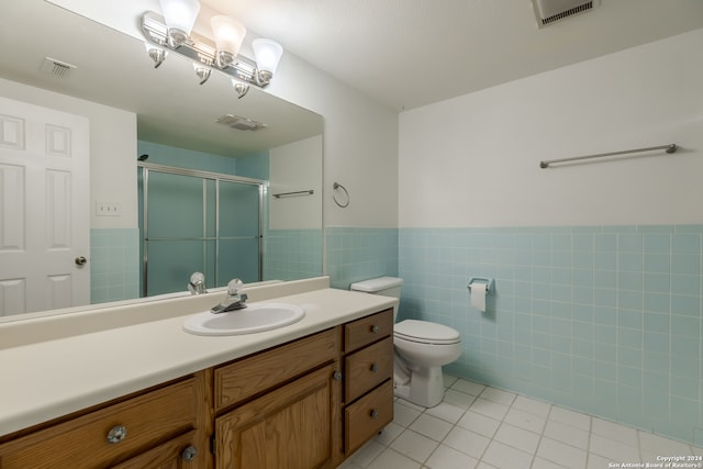 bathroom featuring tile floors, vanity with extensive cabinet space, toilet, and tile walls