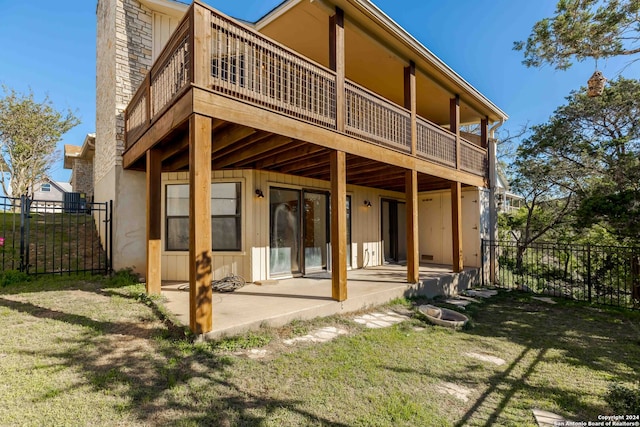 back of property featuring a patio, a balcony, and a yard