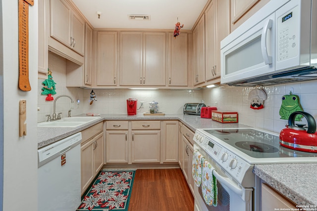 kitchen featuring dark hardwood / wood-style flooring, light brown cabinetry, white appliances, and backsplash