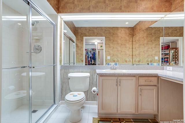 bathroom with toilet, tile flooring, walk in shower, and vanity