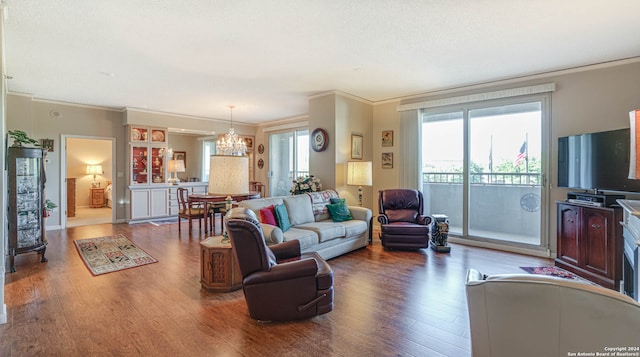 living room featuring crown molding, hardwood / wood-style floors, and a chandelier