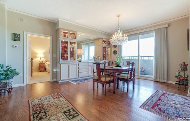 dining area featuring hardwood / wood-style floors, ornamental molding, and a notable chandelier