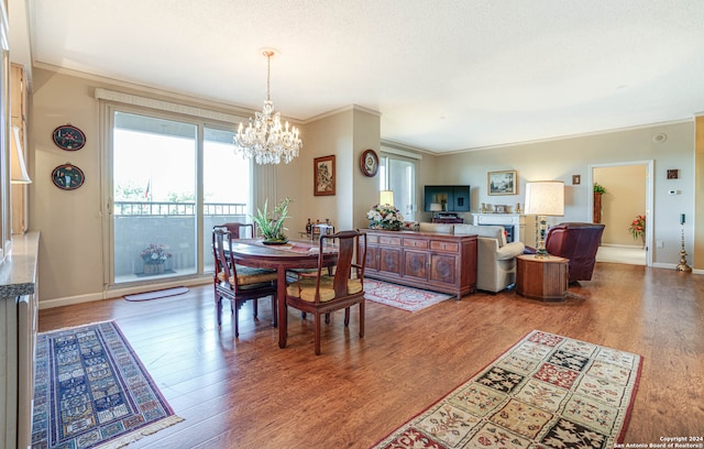 dining area with an inviting chandelier, crown molding, and wood-type flooring