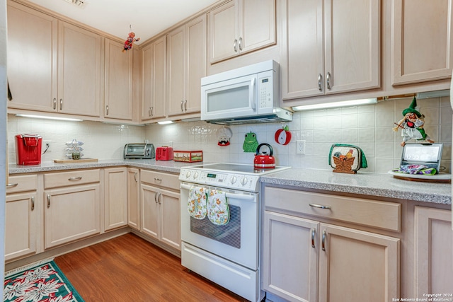 kitchen featuring light brown cabinetry, white appliances, light hardwood / wood-style floors, light stone countertops, and tasteful backsplash