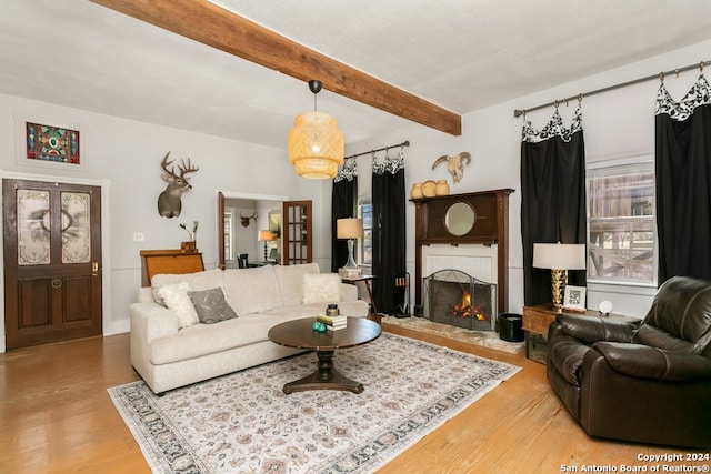 living room featuring beam ceiling and light hardwood / wood-style floors