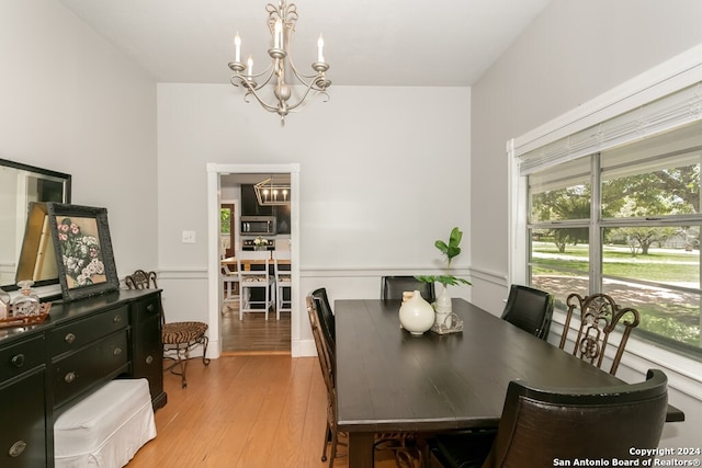 dining space with a chandelier and light hardwood / wood-style floors