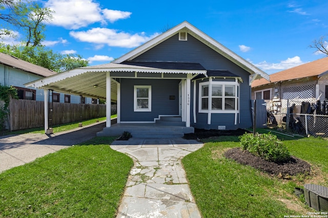 bungalow-style home featuring a carport and a front yard