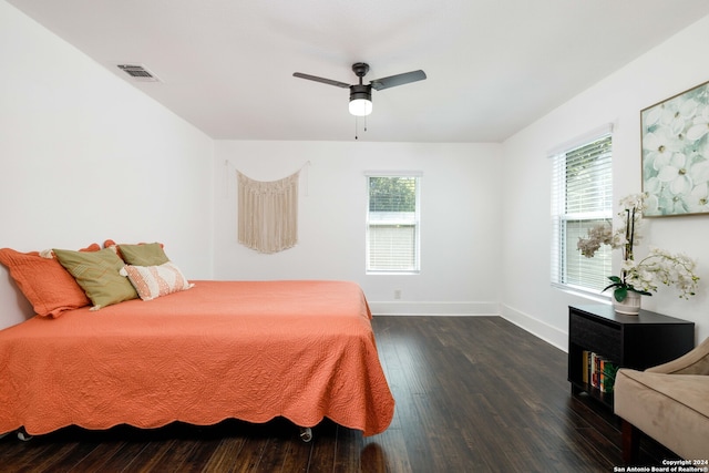 bedroom featuring dark hardwood / wood-style floors, multiple windows, and ceiling fan