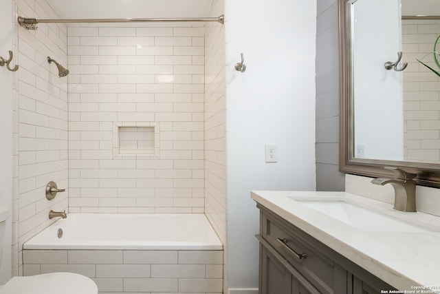 full bathroom with toilet, tiled shower / bath combo, and vanity