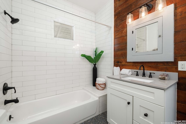 bathroom featuring vanity, wooden walls, and tiled shower / bath combo