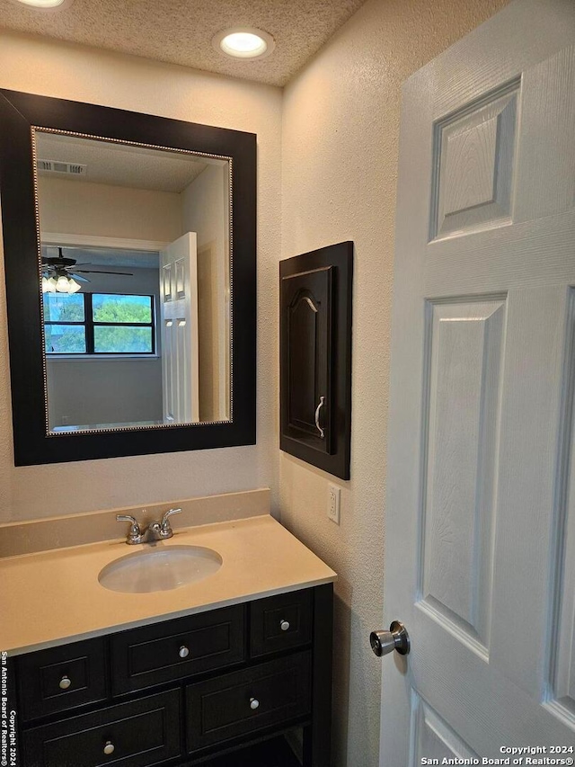 bathroom featuring a textured ceiling, vanity, and ceiling fan