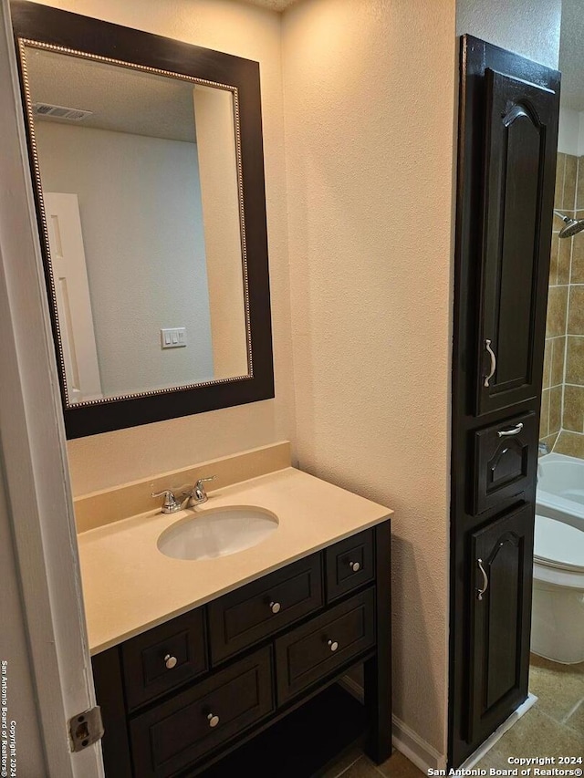 full bathroom featuring tiled shower / bath combo, tile floors, toilet, and vanity