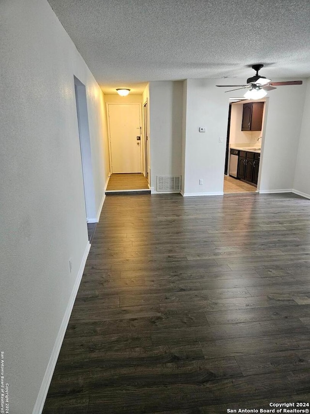 spare room with ceiling fan, dark wood-type flooring, and a textured ceiling