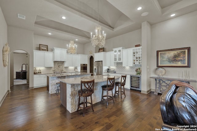 kitchen with stainless steel appliances, dark hardwood / wood-style floors, and white cabinets