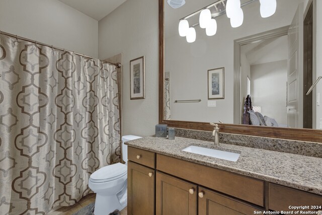 bathroom with tile flooring, vanity with extensive cabinet space, and toilet