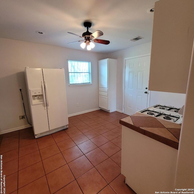 kitchen featuring white appliances, ceiling fan, and light tile floors