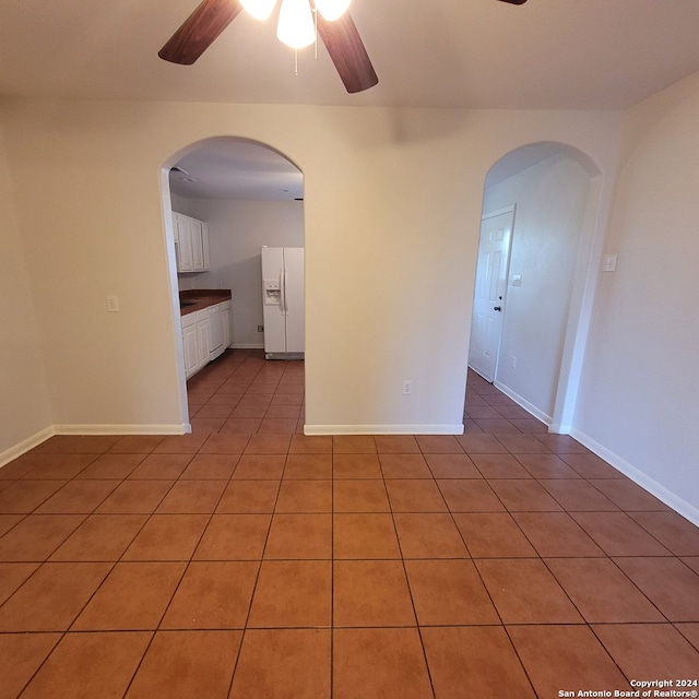 tiled empty room featuring ceiling fan