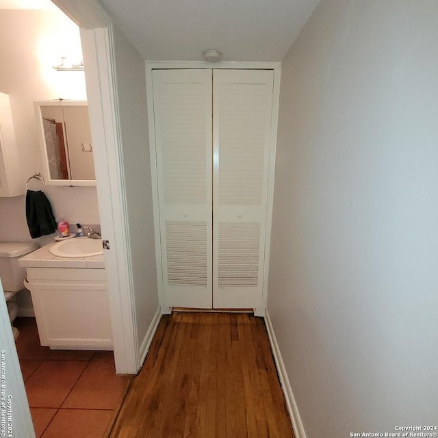 hallway featuring wood-type flooring and sink