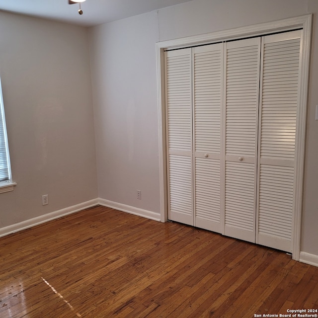 unfurnished bedroom featuring a closet and dark hardwood / wood-style floors