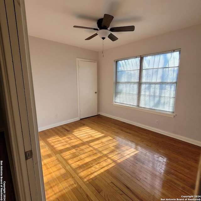 unfurnished room with ceiling fan, light wood-type flooring, and plenty of natural light