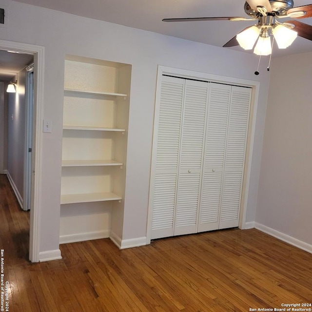 unfurnished bedroom featuring ceiling fan, a closet, and dark wood-type flooring