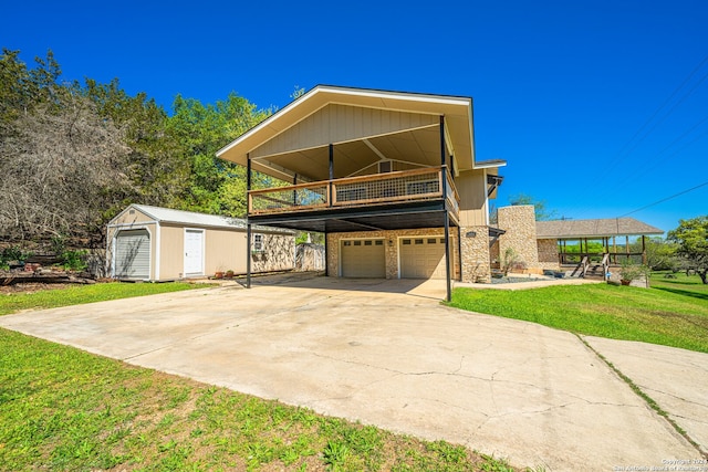 view of front of property with a storage unit, a carport, a front lawn, and a garage