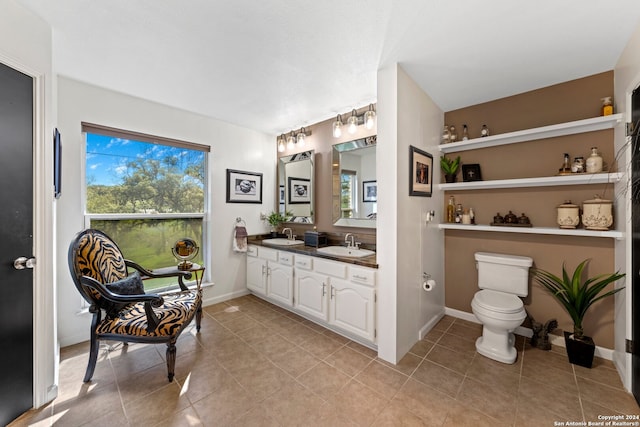 bathroom with double sink vanity, tile floors, and toilet