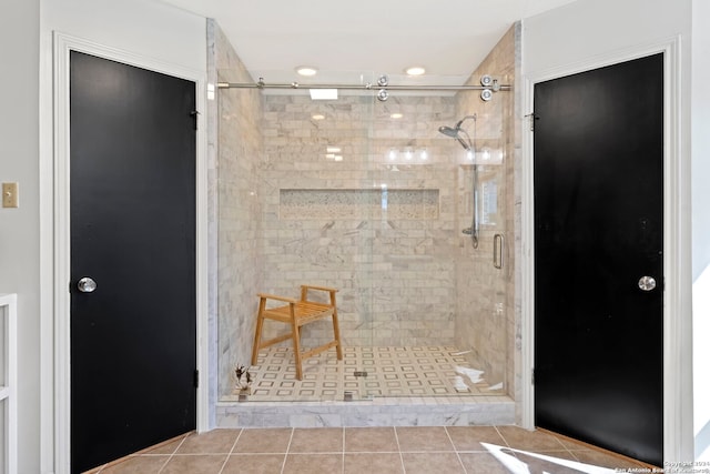 bathroom with a shower with shower door and tile flooring