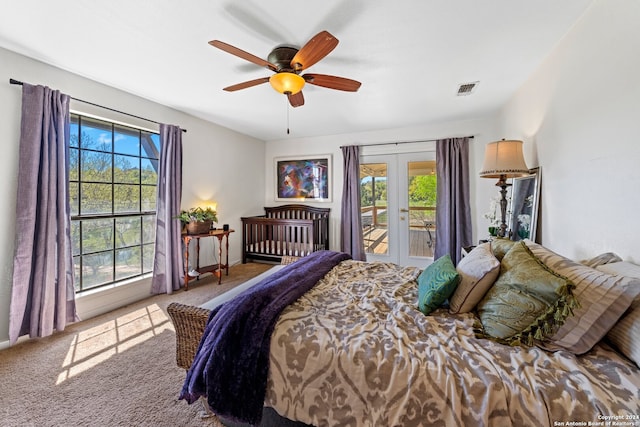 carpeted bedroom with access to exterior, ceiling fan, multiple windows, and french doors