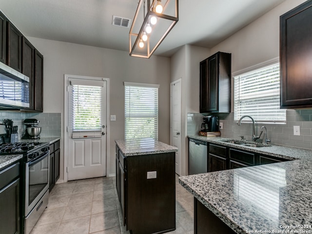 kitchen featuring dark brown cabinets, stainless steel appliances, light tile flooring, tasteful backsplash, and light stone counters