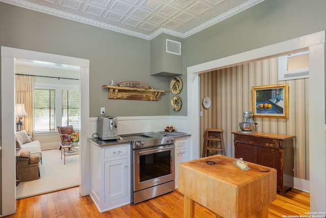 kitchen featuring white cabinets, crown molding, electric range, and light wood-type flooring