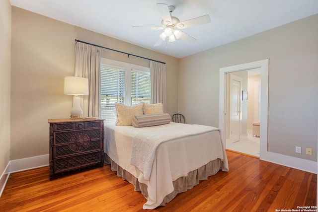 bedroom with ceiling fan, connected bathroom, and light hardwood / wood-style floors